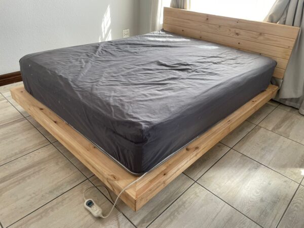 Wooden floating bed with mattress an grey sheet