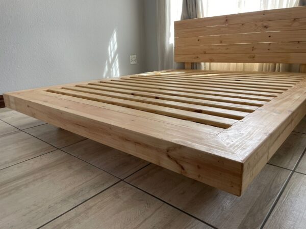 Wooden floating bed with headboard low angle view