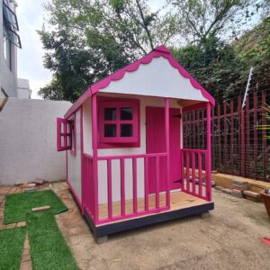 Pink and white wooden playhouse side angle view