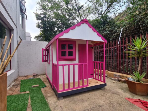 Pink and white wooden playhouse side angle view