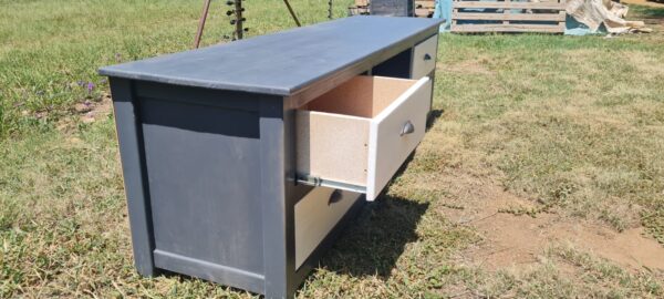 Grey and white wooden tv unit with 4 drawers side view with drawer pulled out