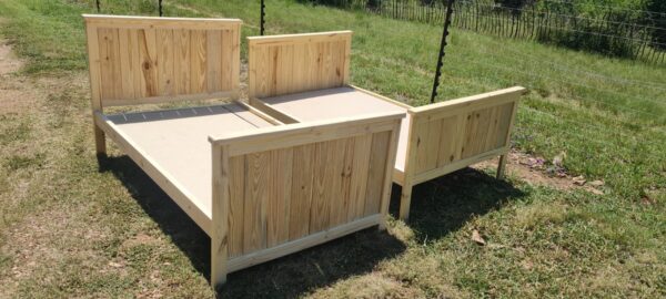 2 single raw wooden kids beds with headboards and footboards angled view