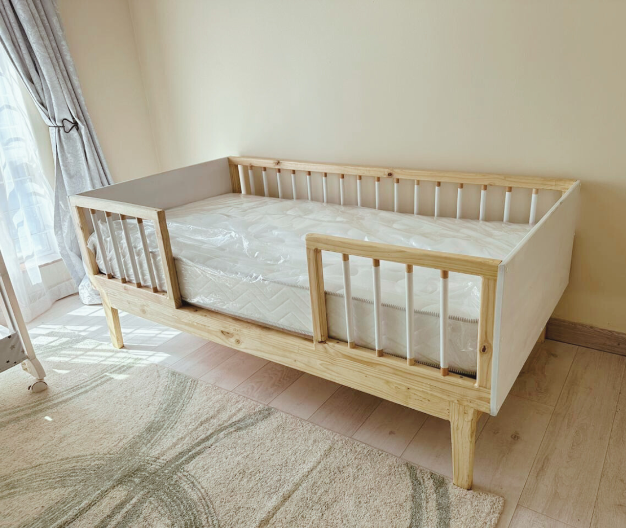 Raw wooden and white rail bed on legs