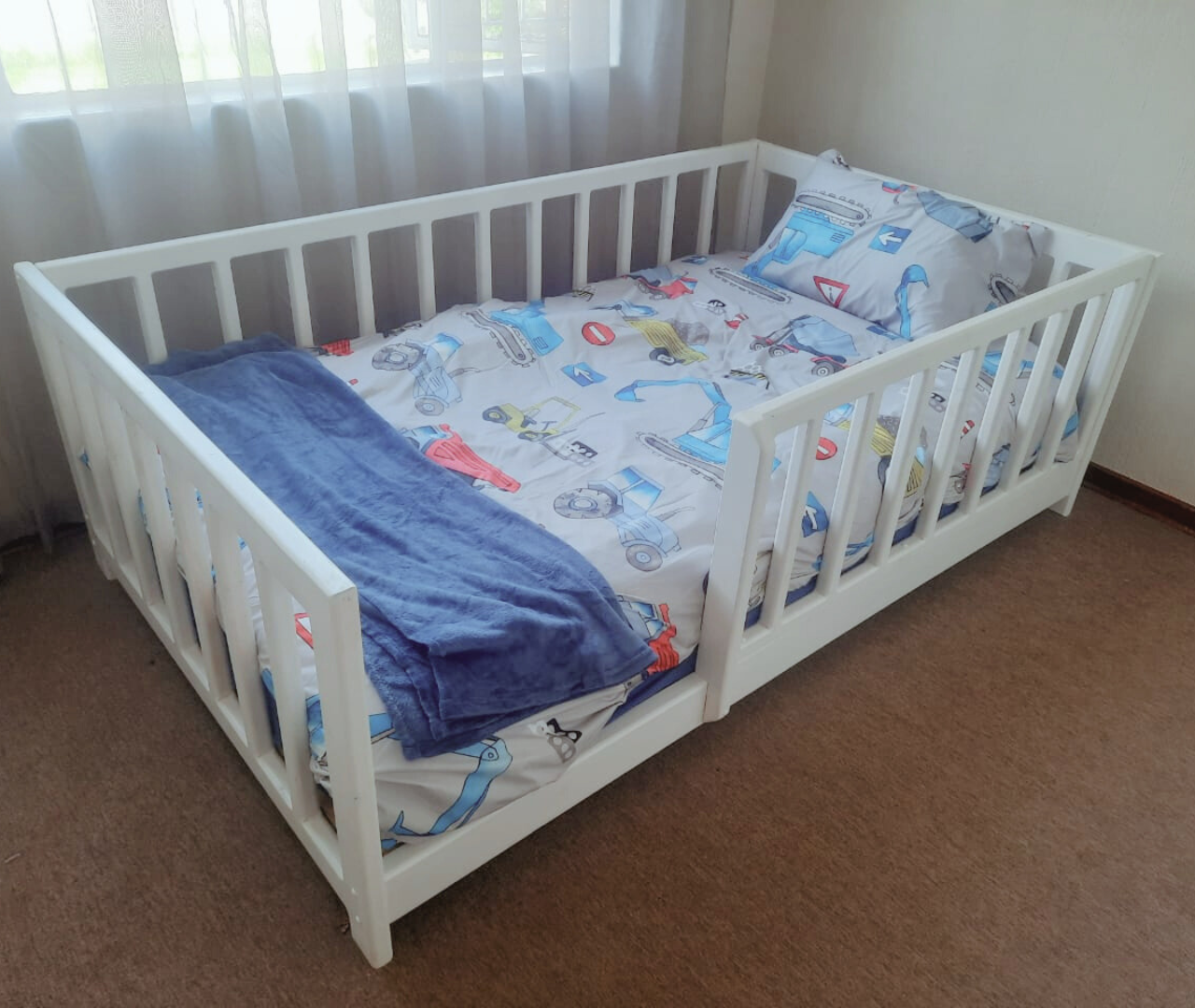 White half rail crib to bed with blue beding