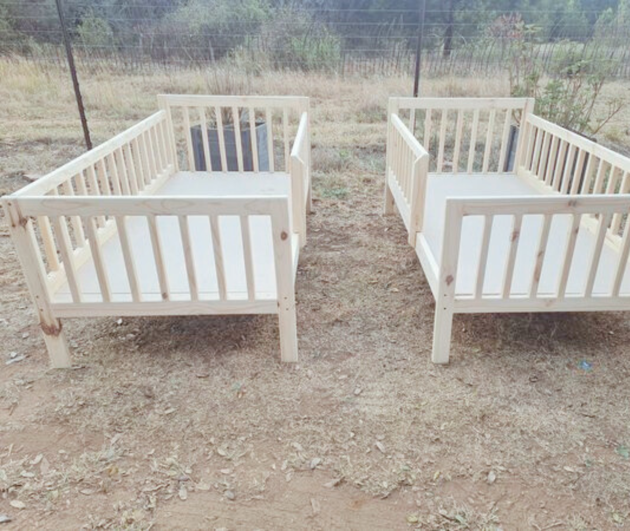 set of raw wooden rail beds displayed outside