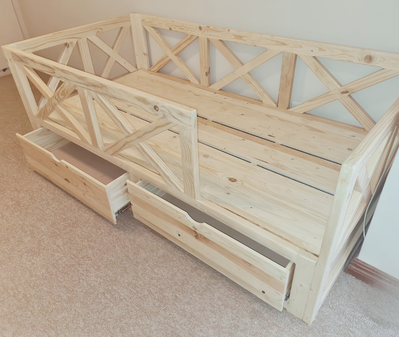 Raw wooden crib to bed floor with kriscross rails