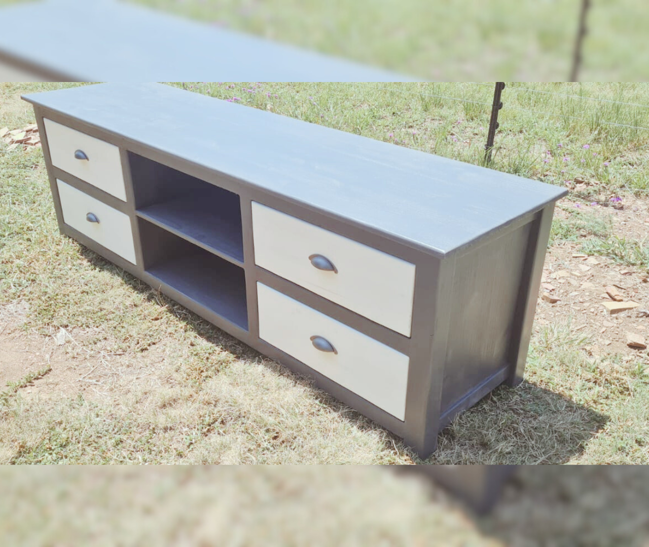 Grey and pine tv unit displayed outside