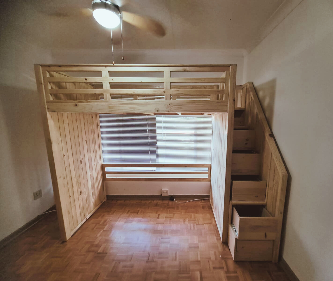 stained wood loft bed with step drawers and book shelf