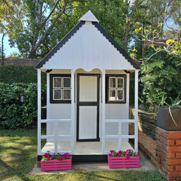 White and black wooden playhouse with pink flower crates