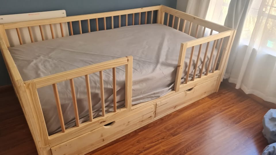 wooden railed kids bed with storage drawers