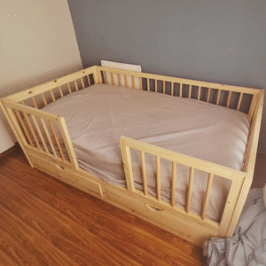 wooden railed kids bed with storage drawers